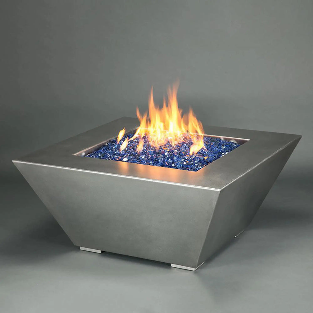 The Starfire Designs Edge Stainless Steel Square Gas Fire Pit filled with vibrant blue fire glass, creating a stunning visual contrast against the sleek, brushed stainless steel finish. This modern fire pit design is perfect for enhancing outdoor spaces, combining both style and functionality for any patio or backyard setting