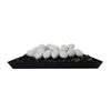 A pile of Starfire Designs white ceramic fire pebbles sitting on top of black fire glass in a tray setup, creating a beautiful contrast between the white stones and the dark background. These heat-resistant fire pebbles are perfect for adding a luxurious touch to gas fire pits and can withstand high temperatures. Ideal for contemporary outdoor decor and enhancing the aesthetic of any fire feature.