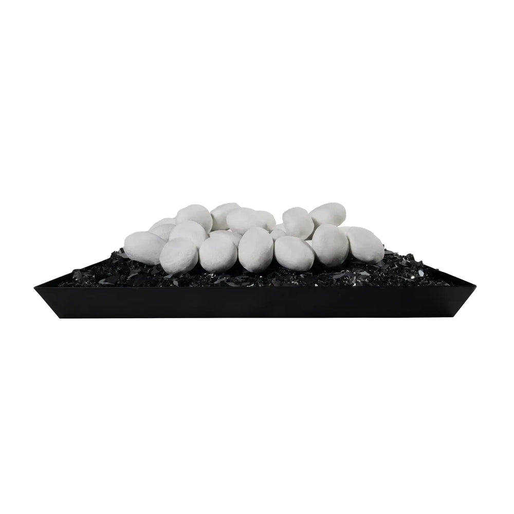 A pile of Starfire Designs white ceramic fire pebbles sitting on top of black fire glass in a tray setup, creating a beautiful contrast between the white stones and the dark background. These heat-resistant fire pebbles are perfect for adding a luxurious touch to gas fire pits and can withstand high temperatures. Ideal for contemporary outdoor decor and enhancing the aesthetic of any fire feature.