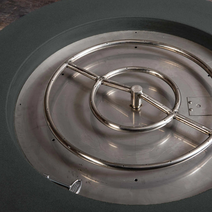 Close-up of the stainless steel burner inside the Starfire Designs Gravity 36-inch Round Concrete Gas Fire Pit in Graphite. The precision-crafted burner ensures even flame distribution, perfect for enhancing outdoor spaces with modern style and reliable warmth