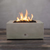 A Starfire Designs Gravity 36" Square Concrete Gas Fire Pit in beige, featuring a warm and consistent flame over lava rocks. The durable concrete structure is built for outdoor use, offering a modern and sleek design for patios. Ideal for year-round gatherings, providing warmth and ambiance with its clean-burning gas operation