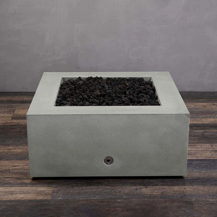 Starfire Designs Gravity 36-inch Square Concrete Gas Fire Pit in natural gray, without flame, showcasing the smooth concrete finish and black lava rocks. This natural gas fire pit is designed for long-lasting use and adds a contemporary touch to any outdoor living space