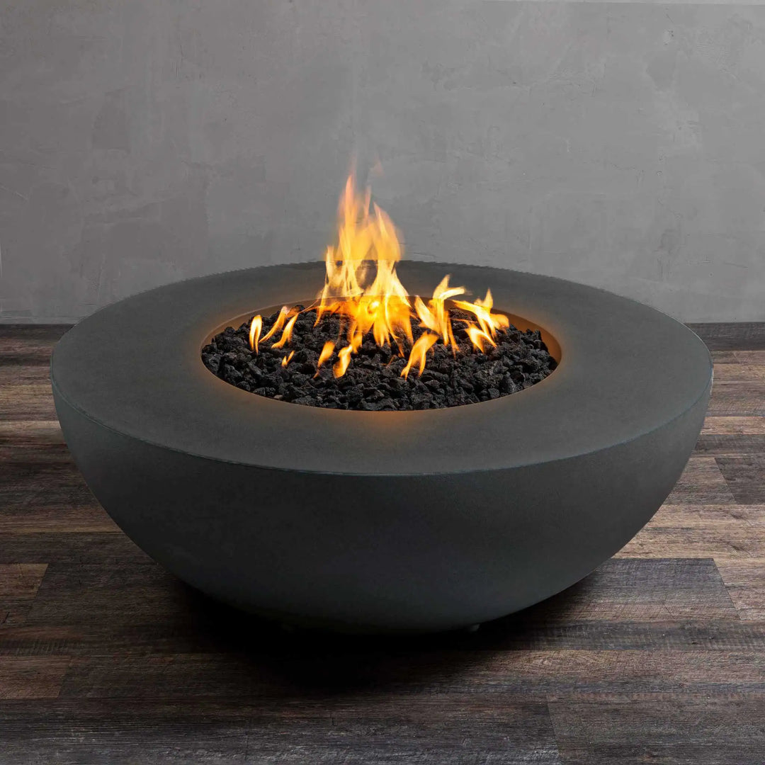 Starfire Designs Gravity 45-inch Round Gas Fire Pit in Graphite, showcasing a bright, natural flame with lava rock inlay. The stylish round shape and durable concrete construction make it an excellent addition to any outdoor patio or garden. The Graphite finish provides a modern, high-end aesthetic for luxury fire pits, outdoor gas fire feature, weather-resistant concrete