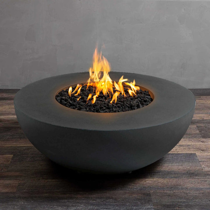 Starfire Designs Gravity 45-inch Round Gas Fire Pit in Graphite, showcasing a bright, natural flame with lava rock inlay. The stylish round shape and durable concrete construction make it an excellent addition to any outdoor patio or garden. The Graphite finish provides a modern, high-end aesthetic for luxury fire pits, outdoor gas fire feature, weather-resistant concrete