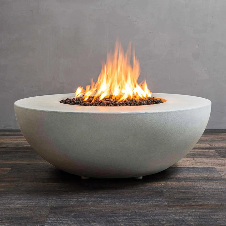 A close-up view of the Starfire Designs Gravity 45" Round Concrete Gas Fire Pit in white, showcasing the active flame. The smooth white concrete surface enhances the modern look, while the fire creates a cozy atmosphere. Ideal for outdoor spaces seeking a sleek, minimalist design. This luxurious fire pit features a durable round shape, premium lava rocks, and a reliable burner system.