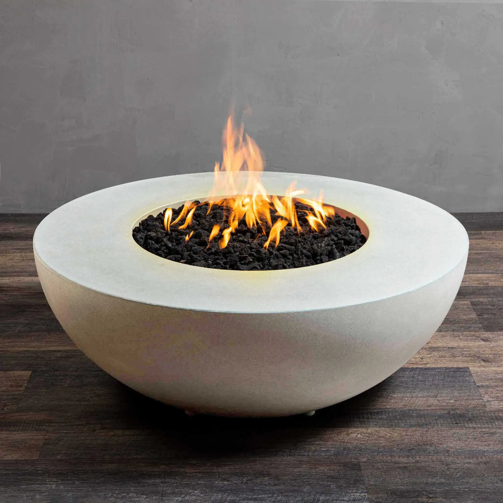 Mid-angle view of the Starfire Designs Gravity 45" Round Concrete Gas Fire Pit in white, highlighting the gentle, even flame rising from the center. The smooth, curved edges of the white concrete body provide a contemporary aesthetic. A perfect addition to high-end patios or outdoor seating areas.