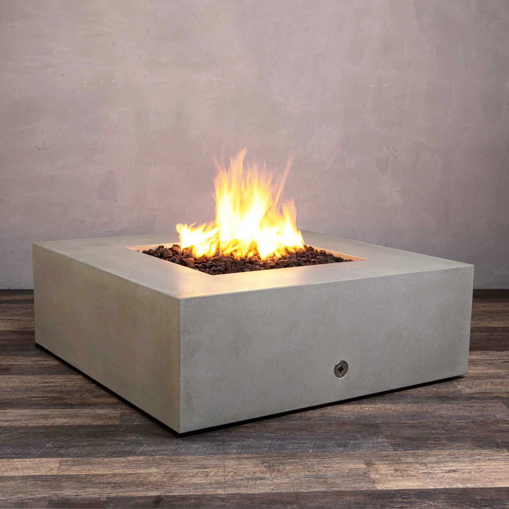 Side-angle view of the Starfire Designs Gravity 45" Square Concrete Gas Fire Pit in beige, displaying a dancing flame above lava rocks. The fire pit’s clean lines and durable concrete construction make it a perfect fit for contemporary patios or garden areas, creating a cozy and inviting atmosphere.