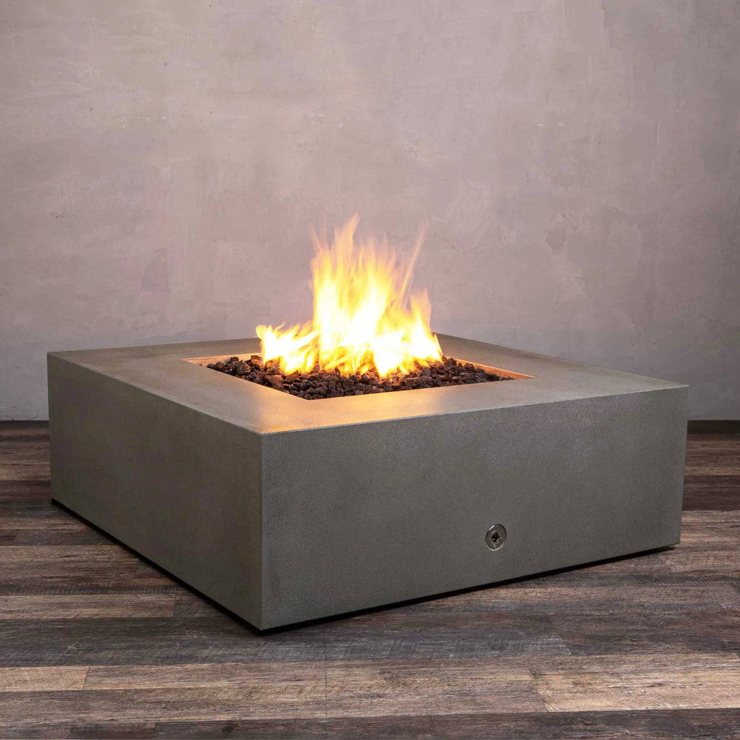 Angled view of the Starfire Designs Gravity 45-inch Square Concrete Gas Fire Pit in brown, showcasing its sleek concrete design and radiant flame. The fire pit is built to withstand outdoor elements while providing a luxurious focal point for outdoor entertainment. Lava rocks surround the burner for an enhanced look.