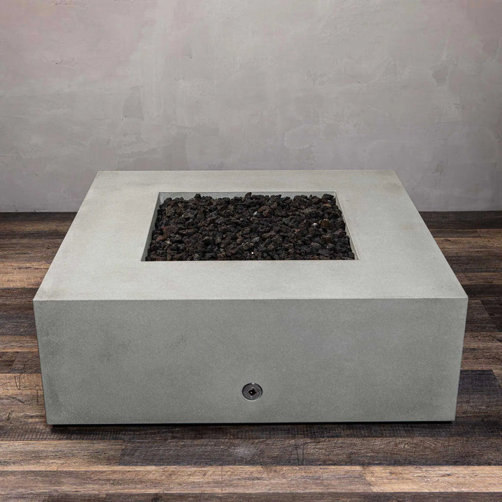 Angled view of the Starfire Designs Gravity 45-inch Square Concrete Gas Fire Pit in natural gray, filled with lava rocks. Ideal for creating a modern outdoor ambiance with a sleek, weather-resistant concrete structure