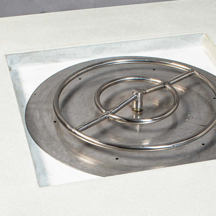 Close-up of the burner inside the Starfire Designs Gravity 45-inch Square Concrete Gas Fire Pit in white, featuring a sturdy stainless steel ring designed for even flame distribution. The burner ensures efficient gas-powered operation, making it a practical and stylish outdoor heating solution