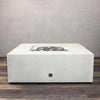 The Starfire Designs Gravity 45-inch Square Concrete Gas Fire Pit in white, with the gas burner system exposed, showing the stainless steel burner. This outdoor fire pit provides reliable gas operation and is built to withstand outdoor conditions, ensuring lasting performance