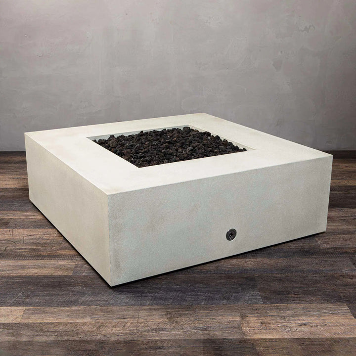 Close-up view of the Starfire Designs Gravity 45-inch Square Concrete Gas Fire Pit in white, with lava rocks arranged neatly in the fire bowl. The solid white concrete body provides a modern touch to outdoor spaces, with a gas burner hidden underneath.