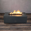 Graphite Starfire Designs Gravity 48" x 32" rectangle gas fire pit, showcasing bright, dancing flames above dark lava rocks. The fire pit's sturdy concrete structure, weather-resistant surface, and refined modern appearance create an elegant outdoor heating solution for patios and decks