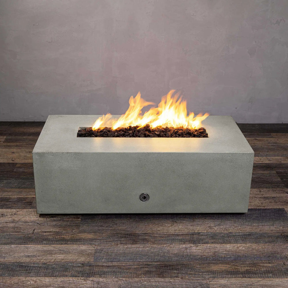 A centered flame view of the Starfire Designs Gravity 48" x 32" rectangle concrete gas fire pit in natural gray. The vibrant flames sit atop dark lava rocks, offering a contrast to the light gray concrete base. Perfect for both commercial and residential use, adding warmth and style to outdoor environments.