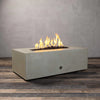 Angled view of the Starfire Designs Gravity 60-inch by 24-inch Linear Concrete Gas Fire Pit in Beige, featuring dynamic flames, perfect for creating a cozy ambiance in any outdoor setting