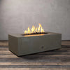 Angled view of the Starfire Designs Gravity 60-inch by 24-inch Linear Concrete Gas Fire Pit in brown, showcasing the modern lines of the fire pit with warm, dancing flames rising from the center, perfect for a stylish outdoor environment