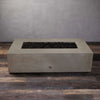 The Starfire Designs Gravity 60" x 32" Rectangle Concrete Gas Fire Pit in beige, shown without the flames, emphasizing its clean, minimalist concrete design. The lava rock bed sits within the rectangular opening, ready for use. This versatile outdoor fire feature blends seamlessly into contemporary or rustic outdoor spaces.