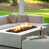 A close-up lifestyle image of the Starfire Designs Gravity 60" x 32" Rectangle Concrete Gas Fire Pit in white, with a cozy flame burning. The fire pitâ€™s sleek concrete surface and minimalist design make it a centerpiece for any backyard or patio area.