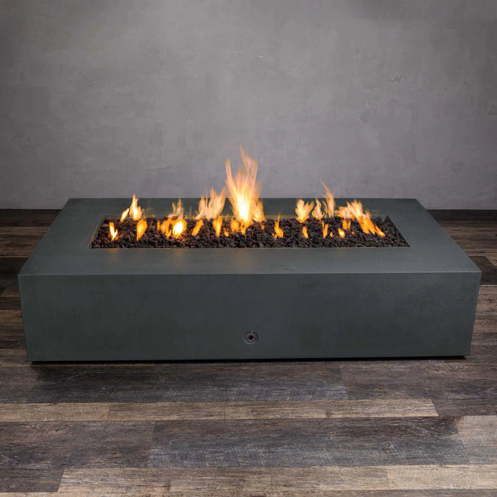 Front view of the Starfire Designs Gravity 72-inch by 38-inch rectangular concrete gas fire pit in graphite, displaying an elegant, low-profile design with a long flame line from the centrally placed burner. The fire pit is shown with flickering flames and dark lava rocks, creating a contemporary aesthetic perfect for modern outdoor spaces. Built from sturdy, weather-resistant concrete, this fire pit is ideal for both residential and commercial use