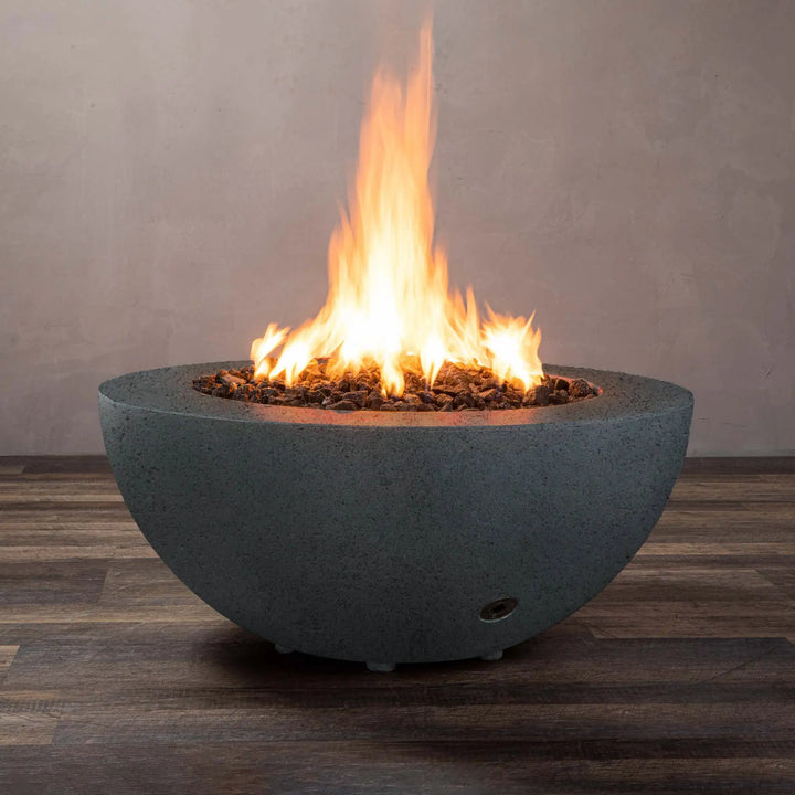 Graphite Starfire Designs Rustic 36-inch round concrete gravity gas fire pit with flames burning, ideal for outdoor luxury settings