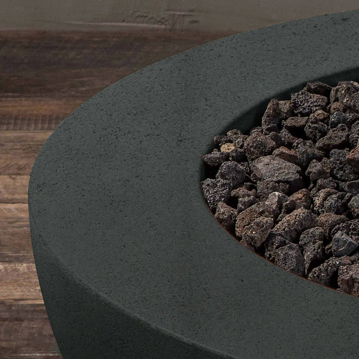 Detailed view of lava rocks inside the graphite Starfire Designs Rustic 36-inch round concrete gravity gas fire pit