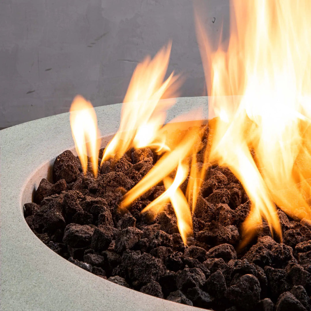 Close-up of the flame and lava rocks in the Starfire Designs Rustic 36-inch Round Concrete Gravity Gas Fire Pit in Natural Gray