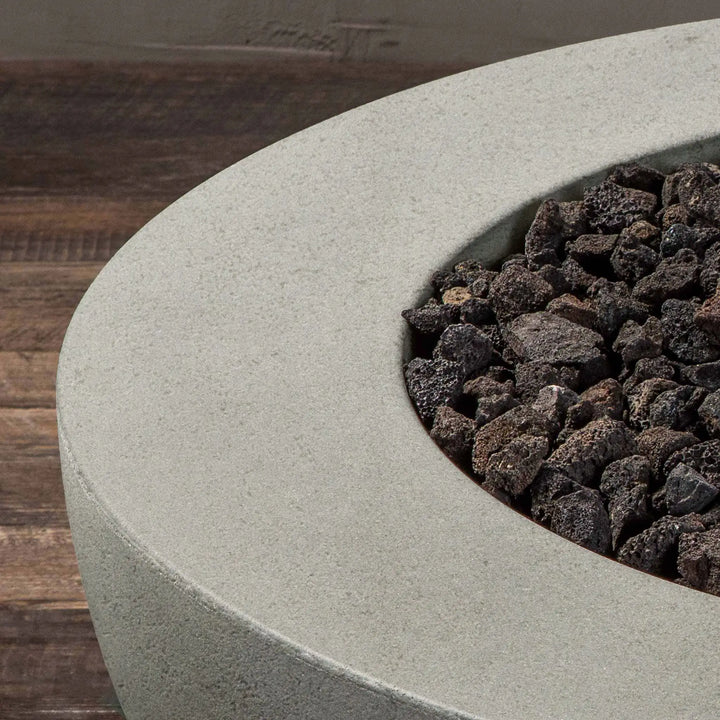 Close-up of the concrete texture and lava rocks in the Starfire Designs Rustic 36-inch Round Concrete Gravity Gas Fire Pit in Natural Gray