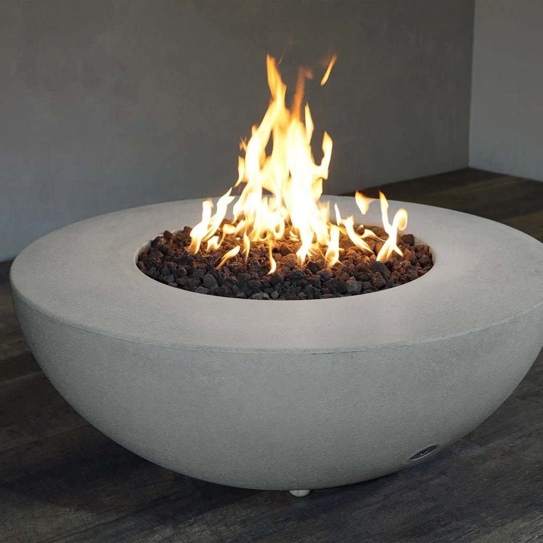 Starfire Designs Rustic 45-inch Round Concrete Gravity Gas Fire Pit in Natural Gray with a roaring fire, perfect for outdoor gatherings