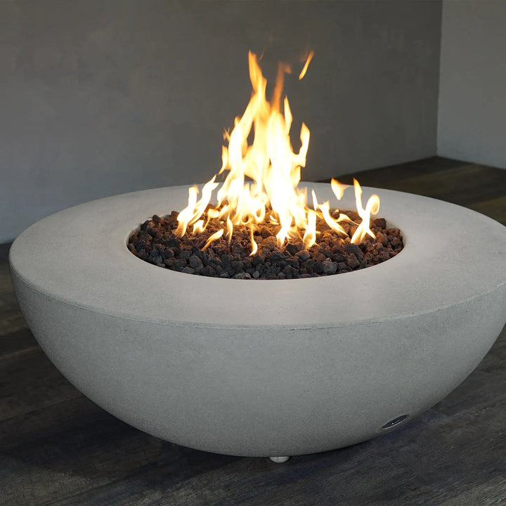 Starfire Designs Rustic 45-inch Round Concrete Gravity Gas Fire Pit in Natural Gray with a roaring fire, perfect for outdoor gatherings