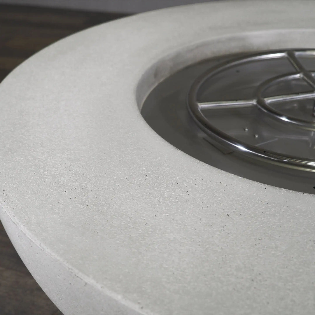 Close-up of the burner on the Starfire Designs Rustic 45-inch Round Concrete Gravity Gas Fire Pit in white, showing the high-quality stainless steel construction for efficient burning