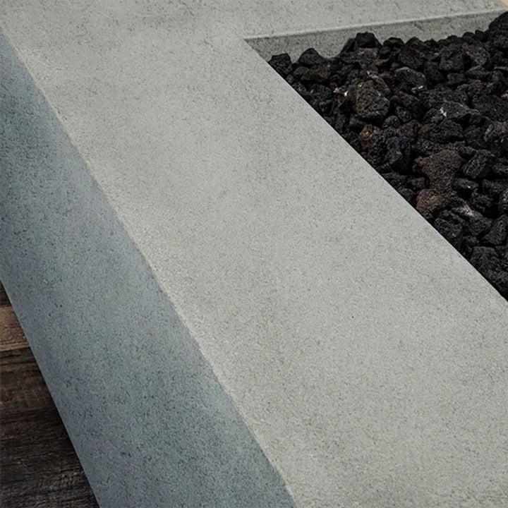 Detail of lava rocks and concrete finish in Starfire Designs rustic 48-inch x 32-inch rectangle concrete gravity gas fire pit in natural gray, adding a natural touch to outdoor fire pit designs