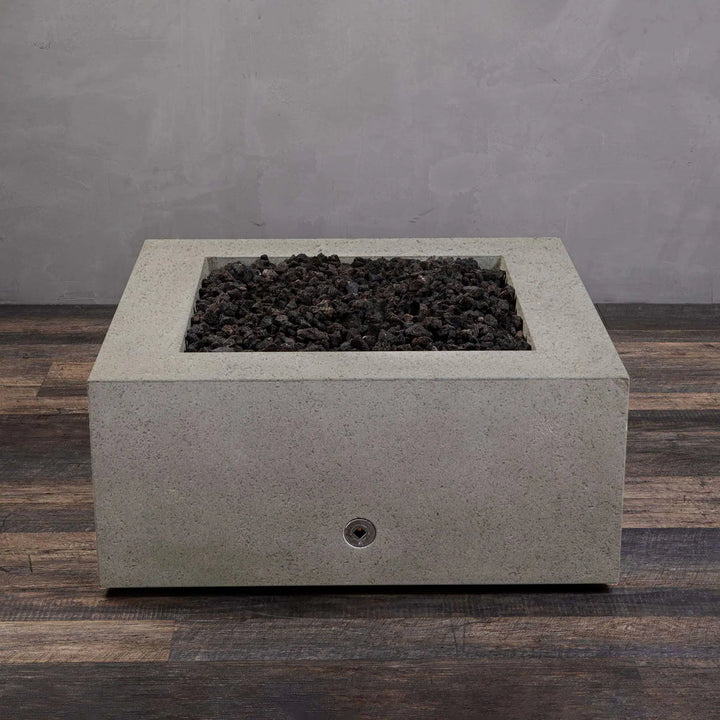 Top view of the empty fire pit bowl in the Starfire Designs Rustic Gravity 36-inch Square Concrete Gas Fire Pit in beige, without the flame, showing the concrete finish and lava rocks