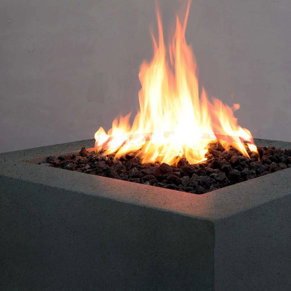 Close-up of the Starfire Designs Rustic Gravity 36-inch Square Concrete Gas Fire Pit in graphite with a glowing fire, emphasizing its sleek and functional design