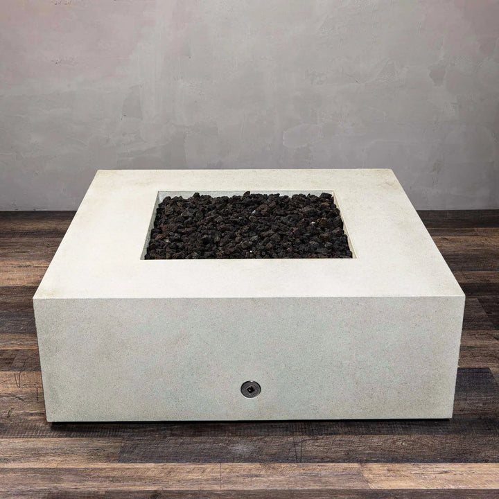 Front view of the Starfire Designs Rustic Gravity 45-inch square concrete gas fire pit in white, with flames rising from the black lava rocks in a modern outdoor setting