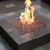 A sleek and modern square outdoor fire pit filled with Starfire Glass 1/2" Broken Fire Glass (10lbs) in Bronze Reflective. The rich bronze tones and mirrored surface create an elegant contrast with the warm flames. This premium fire pit filler is perfect for high-end backyard fire pits, gas fire tables, and commercial fire features.