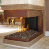 A luxurious three-sided indoor gas fireplace with Starfire Glass 1/2" Broken Pre-Mixed Fire Glass (10lbs), creating a stunning focal point. The fire glass reflects the flickering flames, complementing the ornate bronze fireplace surround. A perfect addition to modern ventless fireplaces, luxury fire pits, and commercial fire pits.