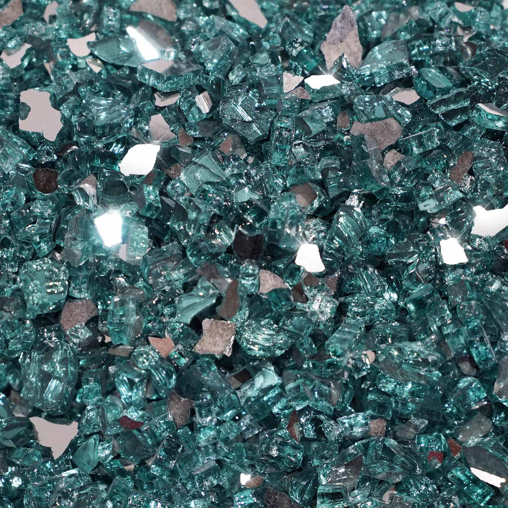 A close-up view of Starfire Glass 1/4" Broken Fire Glass in Azuria Reflective. This fire glass features a vibrant teal color with mirrored surfaces, reflecting light beautifully. Ideal for enhancing outdoor fire pits or backyard fire bowls, it offers a luxurious modern aesthetic and excellent heat resistance. Perfect for commercial or residential fire features.