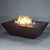 The Starfire Designs Steel Mill 60" x 32" Rectangle Gas Fire Pit in copper vein finish, fully lit with flames rising above the vibrant blue fire glass. This fire pit is perfect for any patio or backyard, providing both heat and ambiance while maintaining a modern and industrial aesthetic