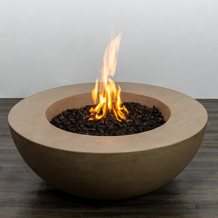 The Starfire Designs Beton 42 Inch Sand Round Concrete Natural Gas Fire Pit with active flames and lava rocks. The bright flames contrast beautifully with the sand-colored concrete, creating a warm ambiance. Ideal for outdoor fire pit gatherings and modern fire table designs.