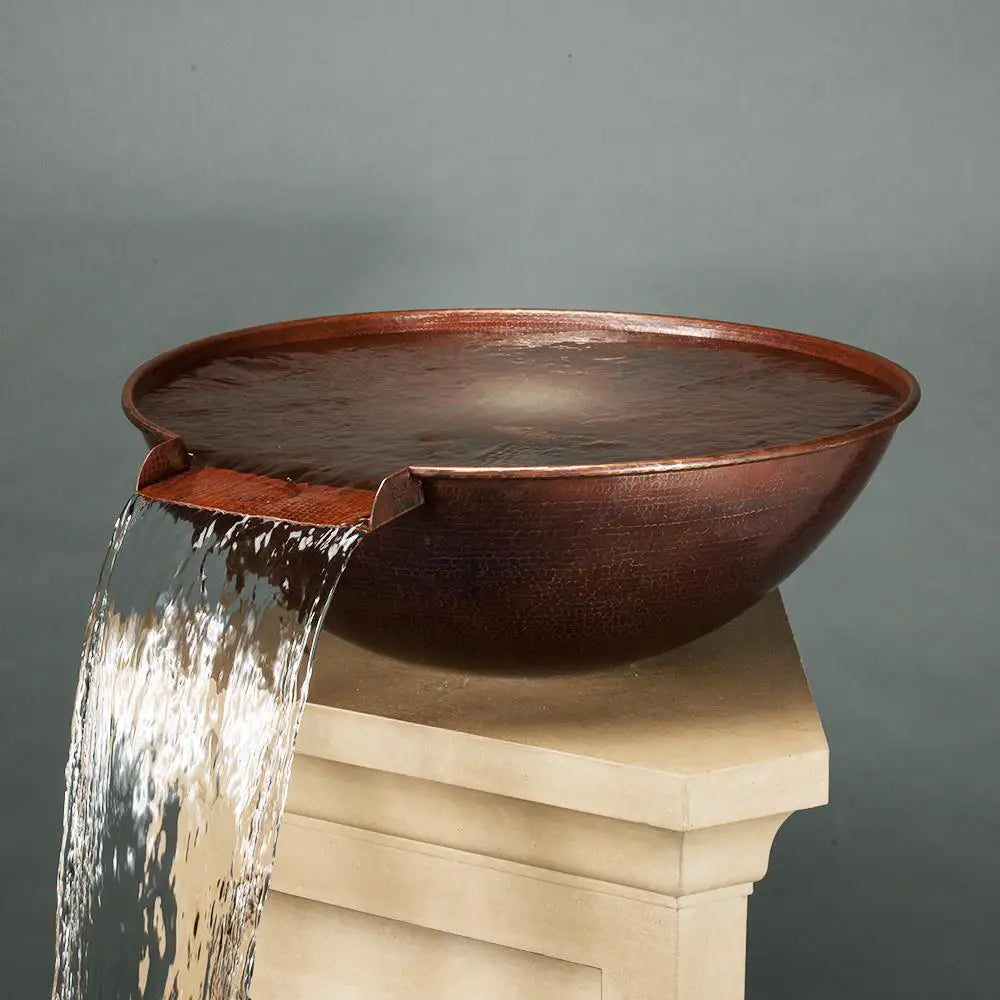 Taza Moreno 30-inch round copper water bowl with cascading water, displayed on a stone pedestal, designed for luxury outdoor environments by Starfire Designs