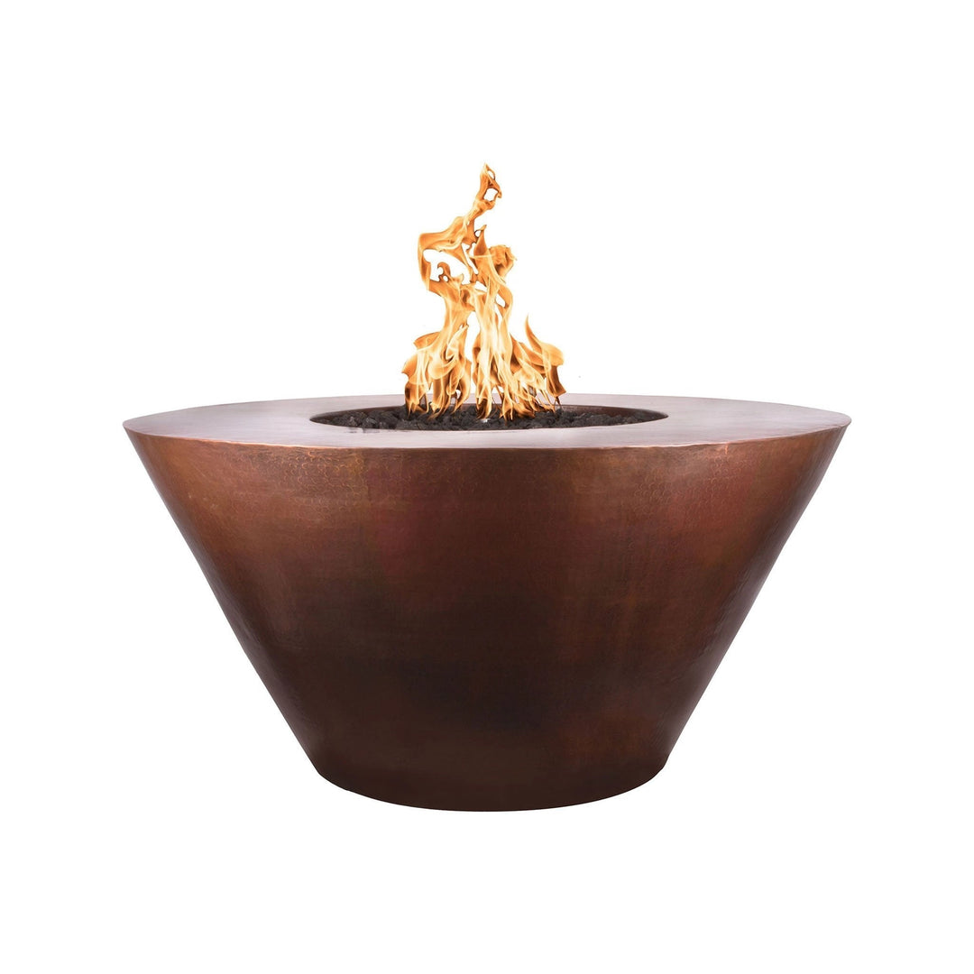 The Outdoor Plus 48-inch Martillo Copper Gas Fire Pit featuring a natural flame in a round, tapered design. This high-quality fire pit is made from premium copper, showcasing a rustic, hammered finish that develops a beautiful patina over time. The wide, flat-top rim provides an elegant contrast to the deep bowl, making it a centerpiece for any outdoor space. The image highlights the warm, inviting glow of the flame, perfect for enhancing backyard gatherings and patio settings. Ideal for use with natural ga