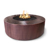 The Outdoor Plus 48-inch Round Unity Fire Pit in a hammered bronze finish, featuring a unique textured surface that adds a sophisticated and elegant look. The deep circular basin is filled with black lava rock, creating a beautiful contrast with the bright flames. Ideal for adding a luxurious touch to any modern outdoor patio or backyard setting.