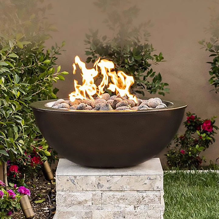 The Outdoor Plus 48-inch Sedona Concrete Gas Fire Pit shown in a close-up view, highlighting its rustic cast stone finish and smooth texture. The fire pit is filled with water and equipped with a stainless steel burner cover. Perfect for both modern and traditional outdoor spaces, this fire pit serves as a versatile and stylish focal point for any patio or garden. Ideal for enhancing ambiance with its elegant aesthetic and durability. Best suited for outdoor fire features, patio decor, and modern fire pit d