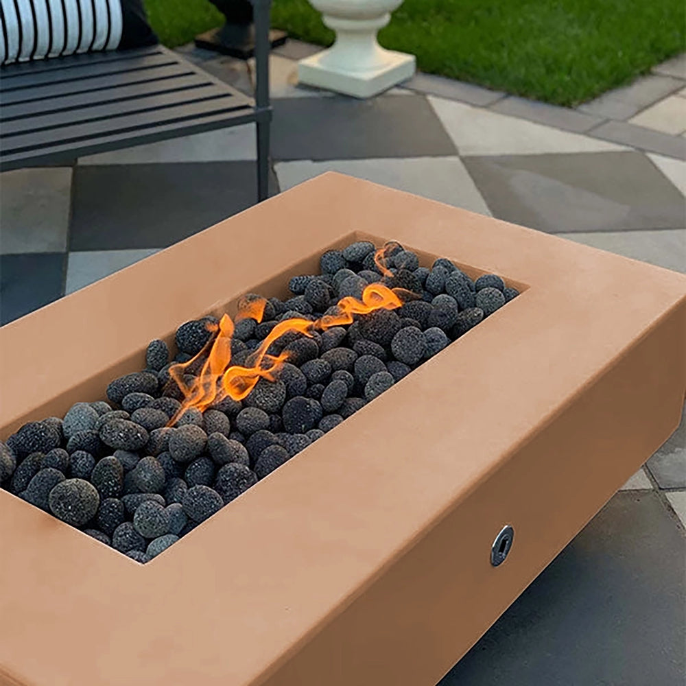 The Outdoor Plus 60-inch Del Mar Concrete Gas Fire Pit in a distinctive copper finish, featuring a patina-like look that adds character to outdoor settings. The lively flames over dark lava rocks make this fire pit a standout feature for any backyard.