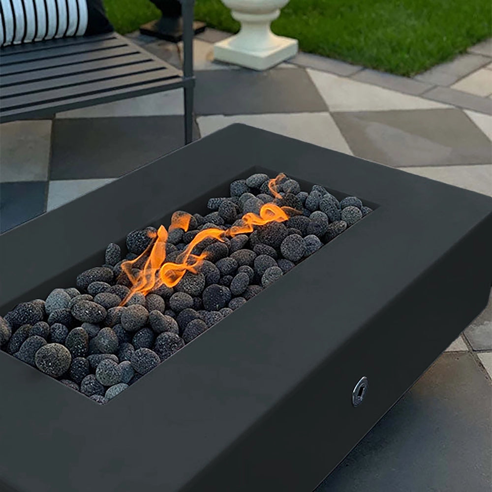 The Outdoor Plus 60-inch Del Mar Concrete Gas Fire Pit in slate color, featuring a smooth, modern design that enhances backyard settings. This gas fire pit provides a beautiful flame display over dark lava rocks, ideal for contemporary patios or garden areas. A perfect outdoor fire feature for sleek and sophisticated decor.