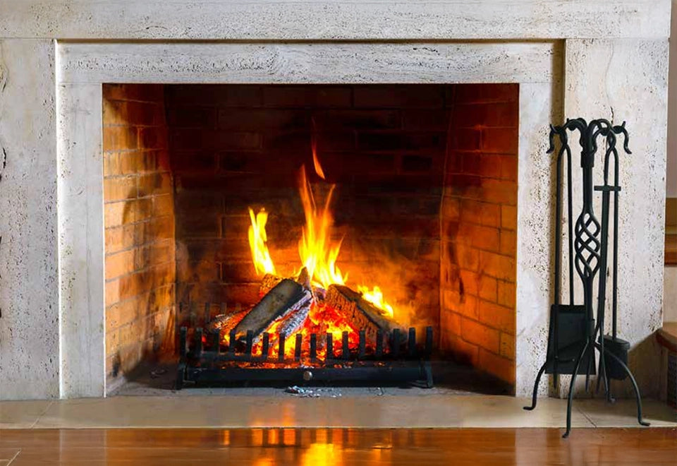 Classic brick fireplace with vibrant flames and natural wood logs, accompanied by a black wrought iron fireplace tool set, creating a warm and inviting ambiance.