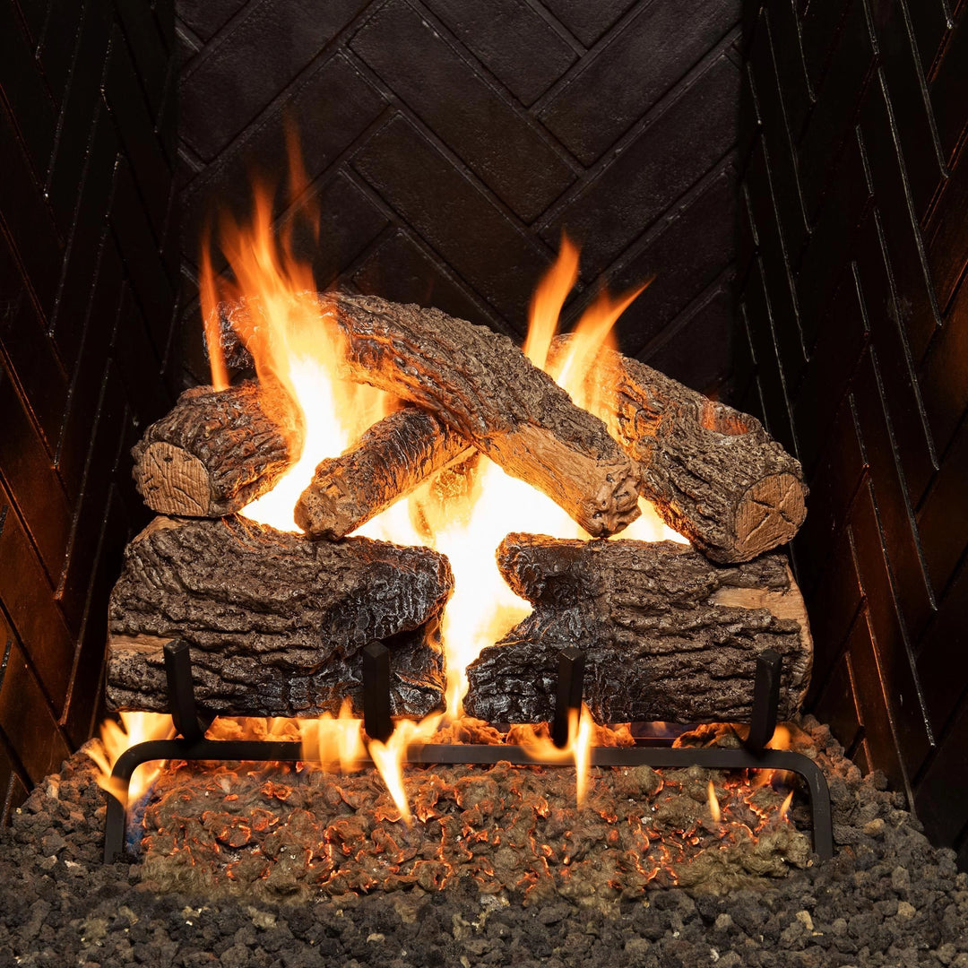 A 16-inch Real Fyre vented Charred Oak gas log set ignited with vibrant flames in a black herringbone fireplace. These gas logs feature authentic charred oak textures and detailed bark, creating a warm and inviting atmosphere in your living space.